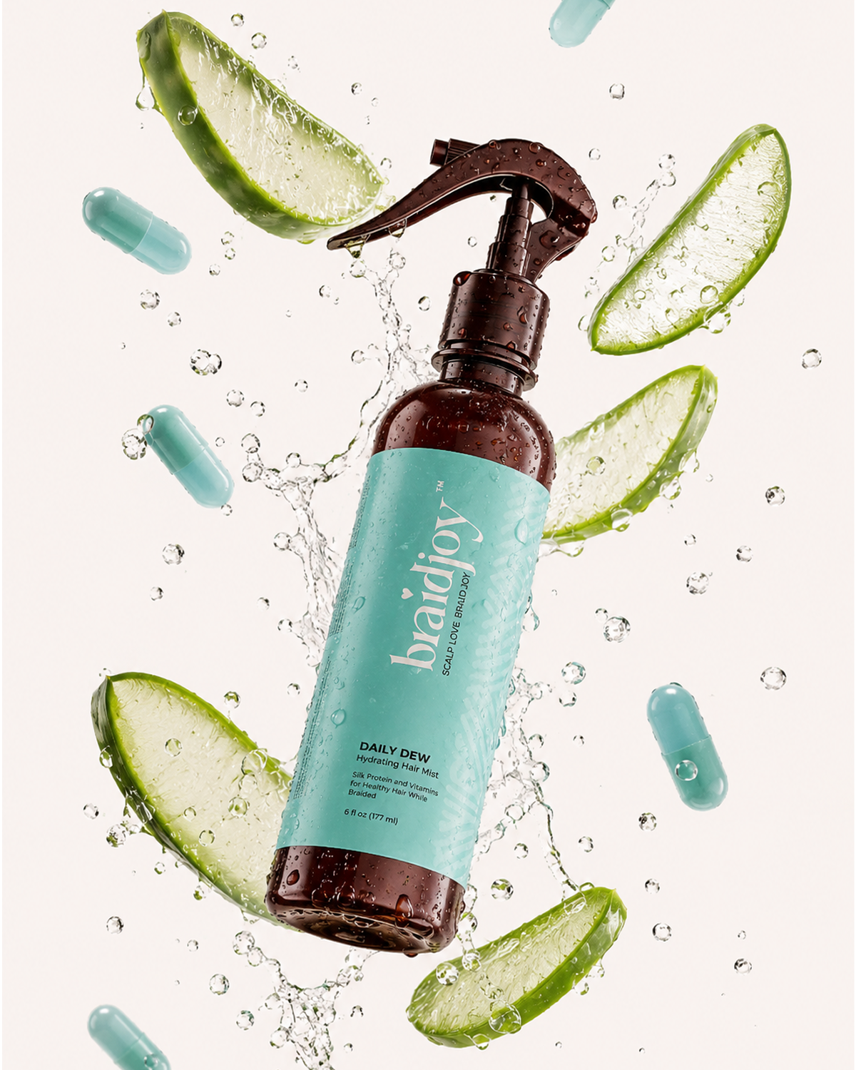 Amber braidjoy Daily Dew hydrating hair mist with a teal label surrounded by splashing water, aloe slices, and vitamin capsules, highlighting lightweight hydration, silk protein, and vitamins for healthier hair while braided.