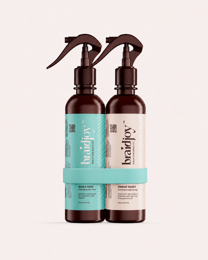 Two amber braidjoy spray bottles in a teal holder, featuring Daily Dew hydration mist and Sweat Reset cooling scalp spray for lightweight moisture, scalp refreshment, sweat buildup control, and healthier hair after braids.