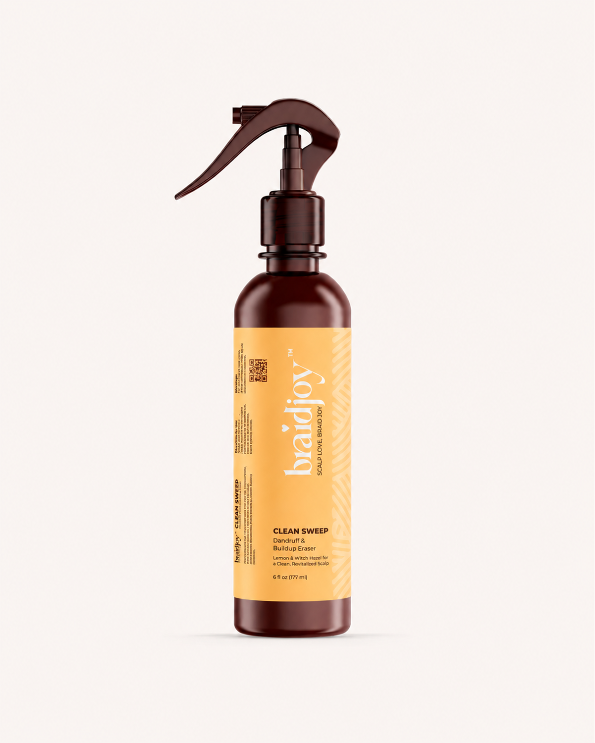 Amber braidjoy Clean Sweep spray bottle with a yellow label on a light background, designed as a pre-shampoo scalp detox that breaks down product buildup, dandruff, and dirt knots while leaving the scalp refreshed with a lemony-mint feel.